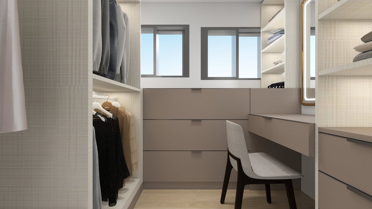Modern walk-in closet with built-in shelving, drawers, clothing racks, white chair, and windows providing natural light