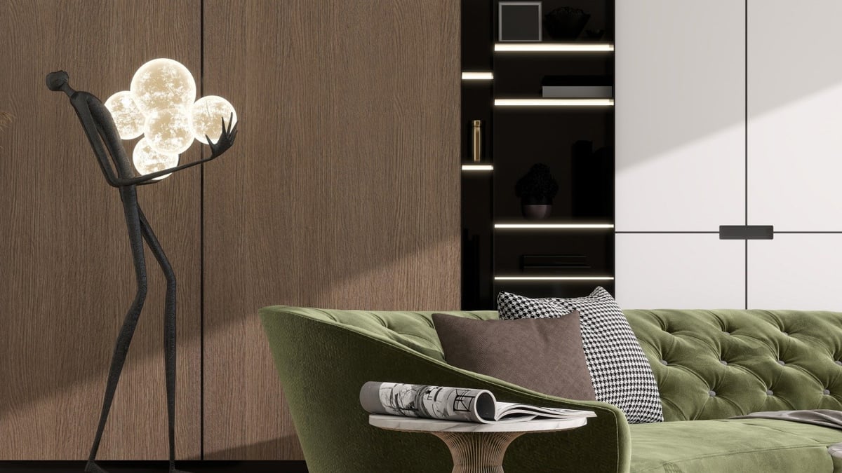 Modern living room with green velvet sofa, sculptural floor lamp with white shade, and built-in black shelving