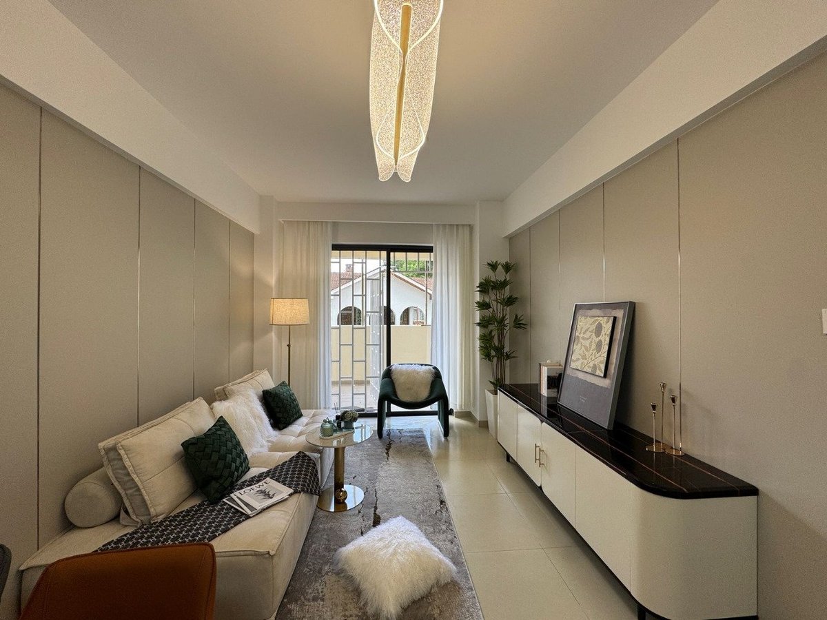 Modern living room with beige sofa, black accent chair, white TV stand, and glass doors leading to outdoor space