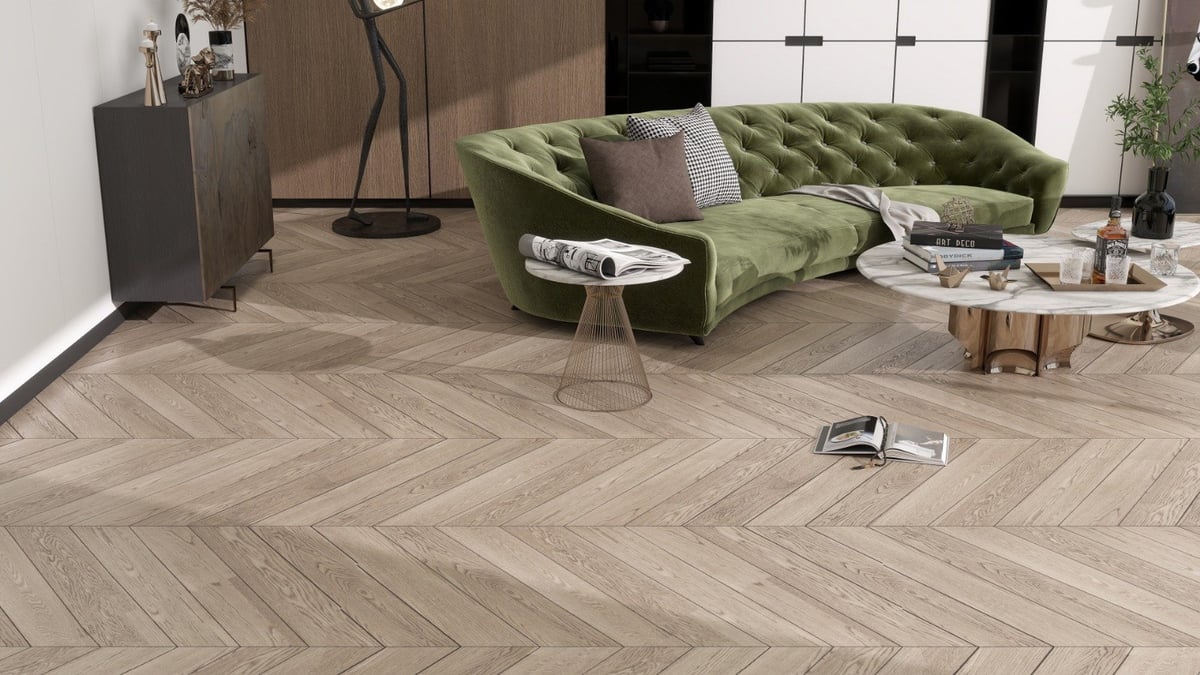 Modern living room with herringbone wood flooring, green velvet sectional sofa, wooden coffee tables, and contemporary furnishings