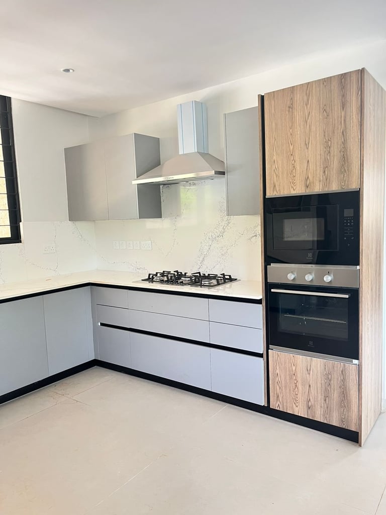 Modern kitchen with white lower cabinets, wood-grain upper cabinets, stainless steel appliances, gas cooktop, and white marble backsplash